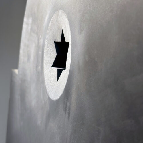 Concave circle carved in relief, with a star in the middle on black slate.