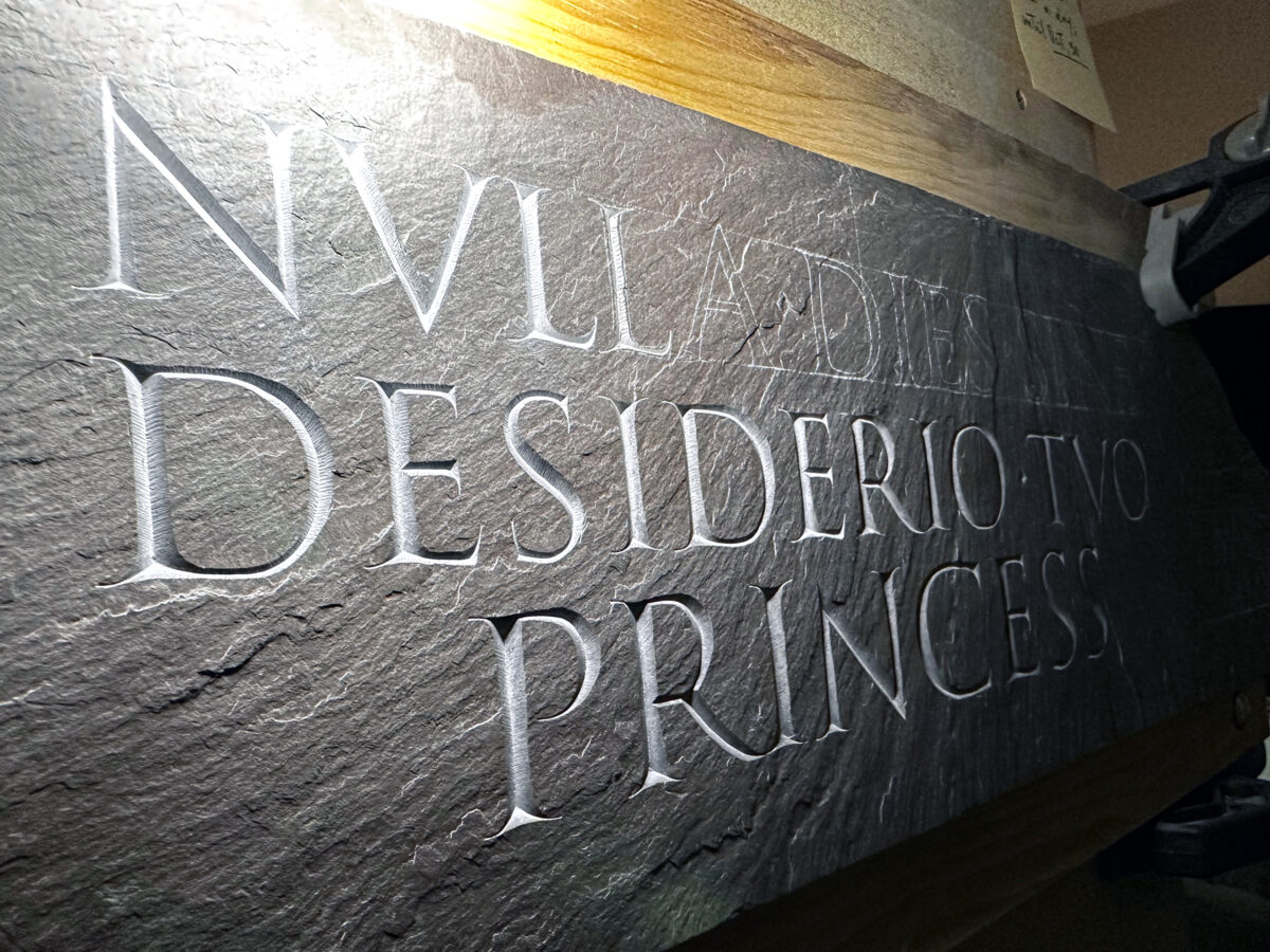 Close-up of carving process, some letters are finished, others are in mid-progress