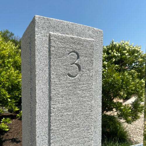 A large granite post image with a large number 3, carved into the stone