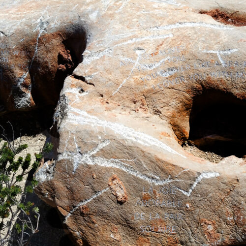 A medium shot of a large granite with blocks of text carved into it. IBIZA, SPAIN.
