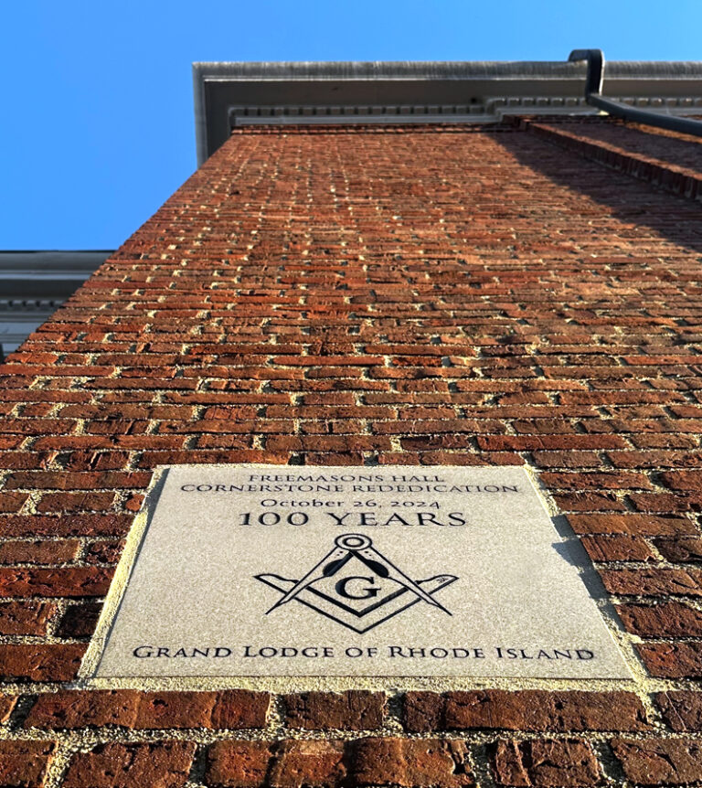 Upshot of a Brick building showing the westerly granite cornerstone with letter carved by Javier R. Alfonzo, for the Grand Lodge of Rhode Island as part of the 100 years rededication in 2024.