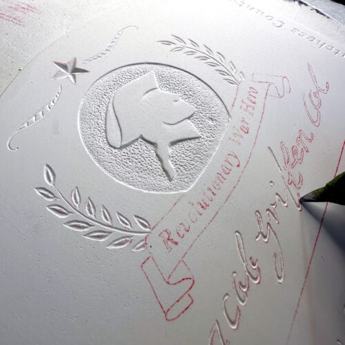 Closeup of a positive plaster cast. Hand carving the plaster's lettering.