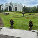 Wide shot of a garden at the Salve Regina University. At the bottom of the image a stone step shows details of a benefactor's name carved into the stone.