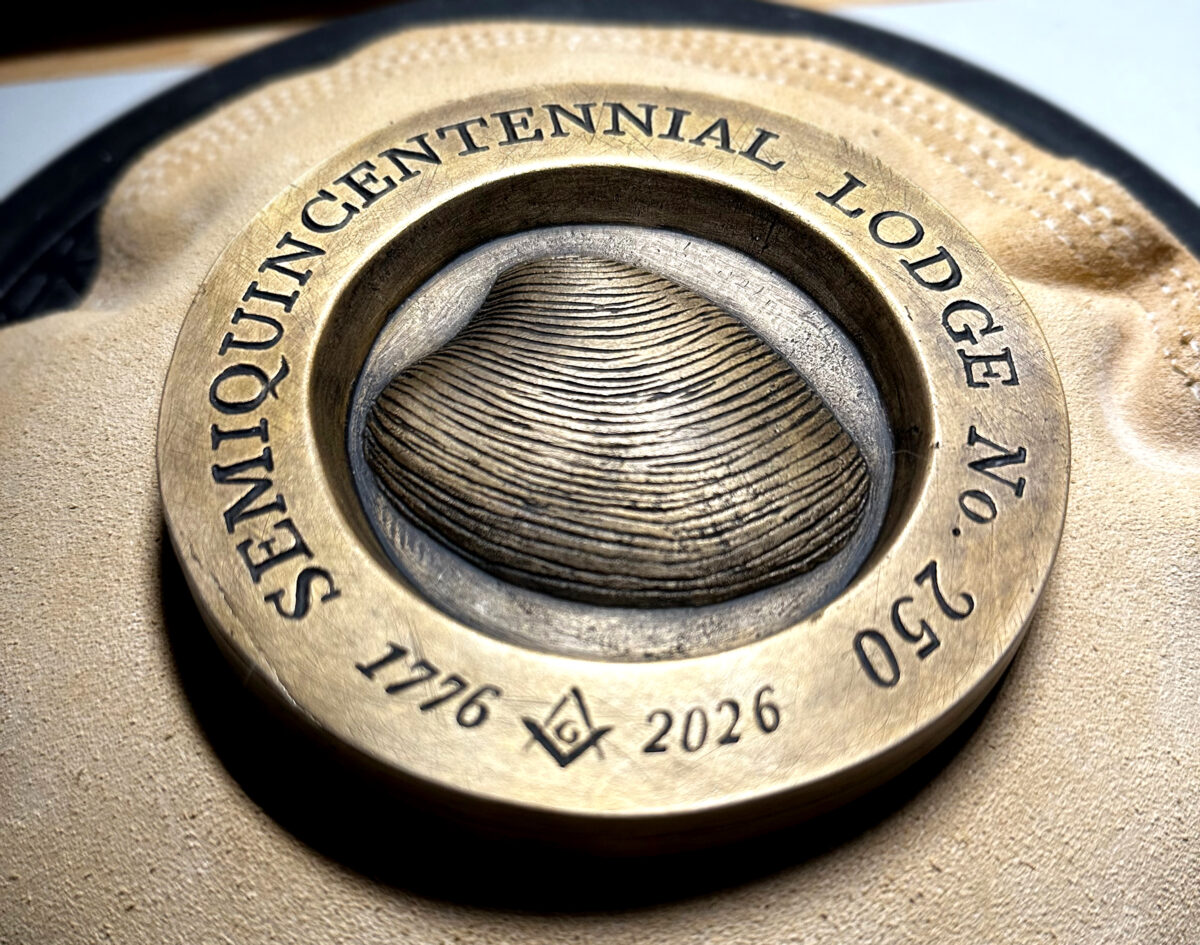 Close-up shot of the Semiquincentennial Lodge No. 250 bronze striker with detail of the tool marks showing.