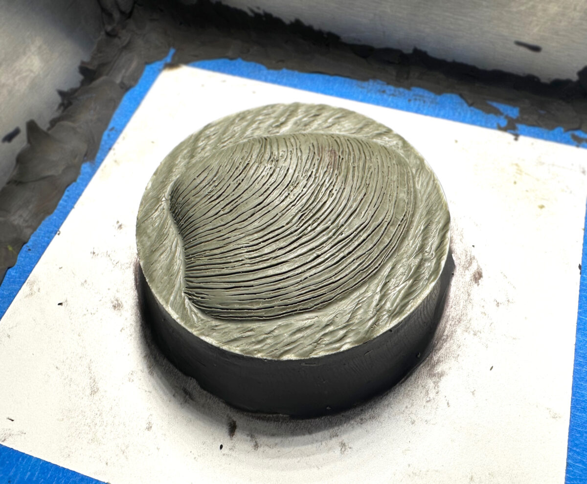 Image of the clay model, ready for a plaster mold. Details of a subtle shoreline and tide.