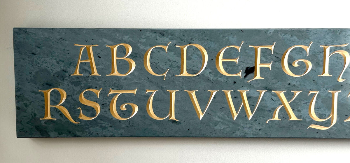Full shot of a green Vermont slate alphabet inscription with painted lettering.